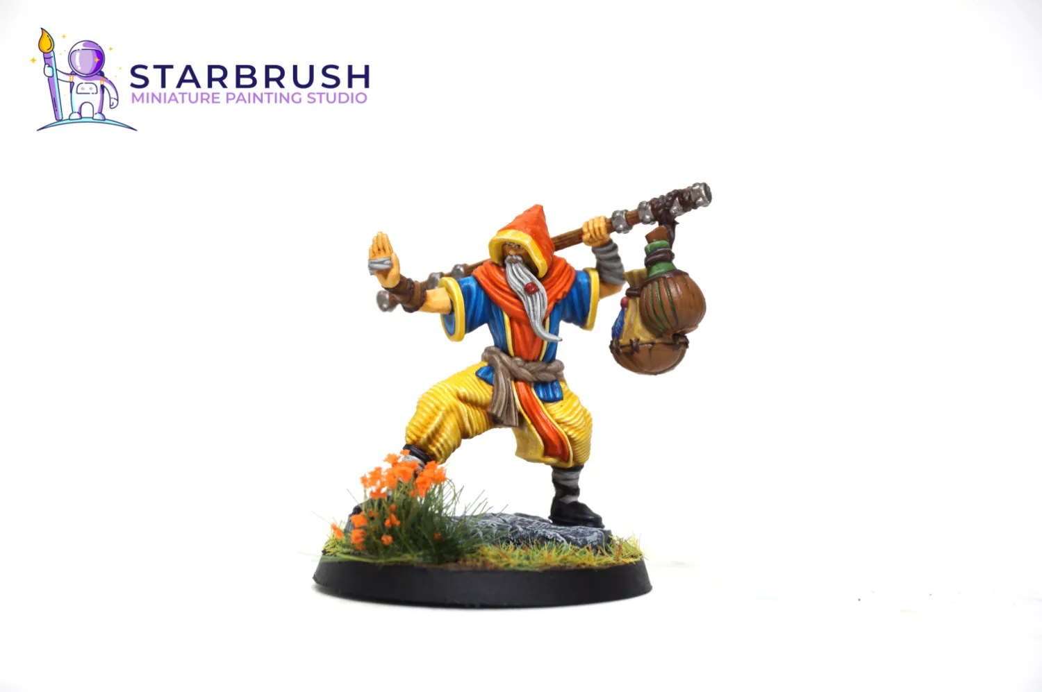 Miniatura de personaje monje viajero para juegos de rol de fantasía con ropajes naranja, azul y amarillo pintado a Nivel 2 por Starbrush Studio en febrero de 2023