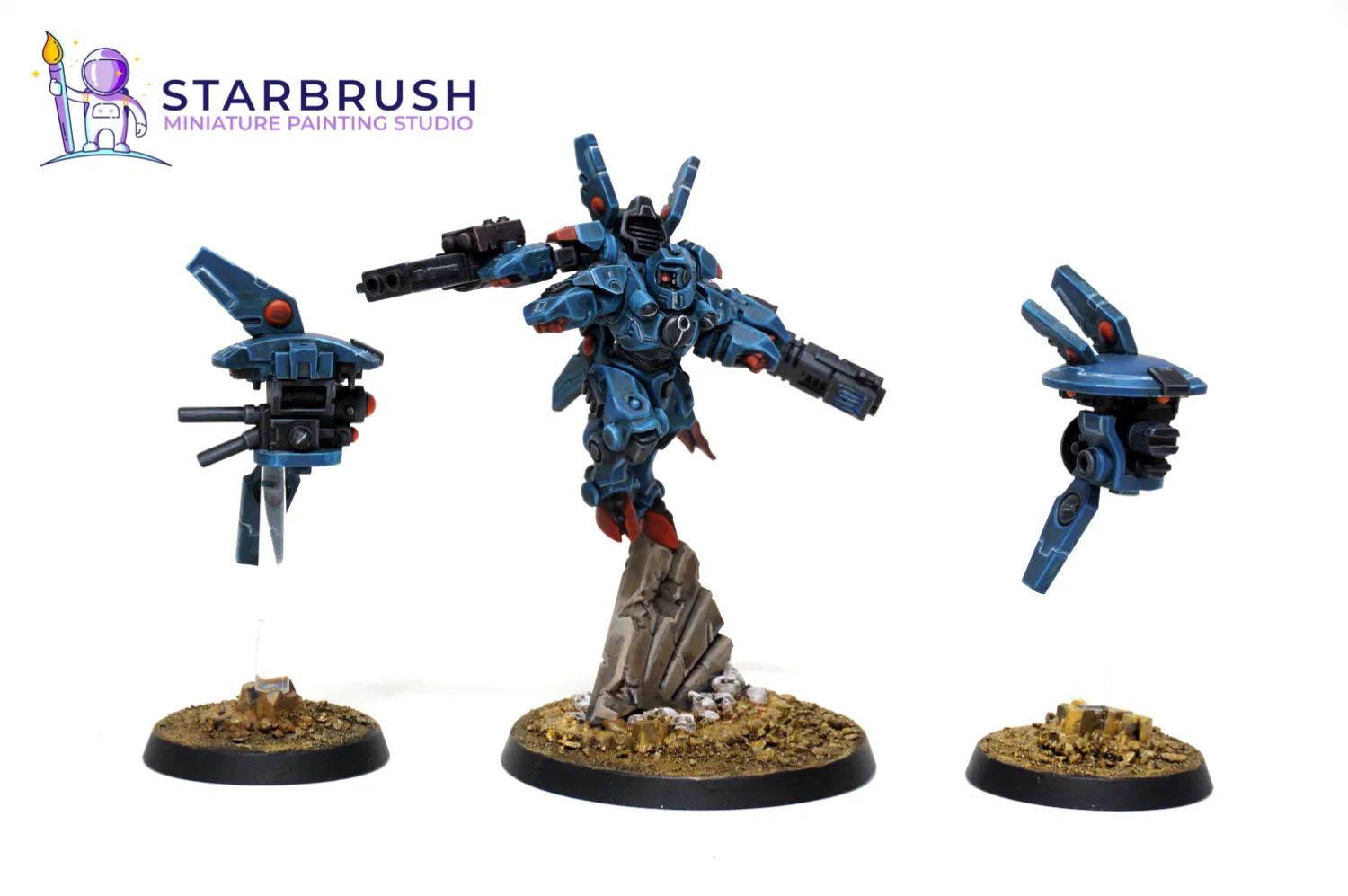 Commander Shadowsun T'au Empire miniature with two drones in a dark blue scheme painted to Level 2 by Starbrush Studio over ruins